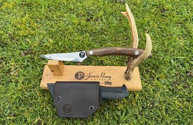 wooden handle drop point hunting knife on stand
