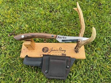 wooden handle drop point hunting knife on stand