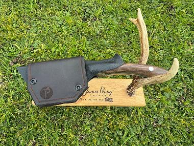 wooden handle drop point hunting knife on stand in sheath